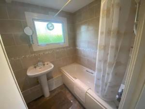 a bathroom with a sink and a toilet and a tub and a sink at Cosy Cornish Chalet Camelford Port Isaac in Camelford