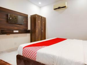 - une chambre avec un lit et une télévision murale dans l'établissement OYO Flagship Golden A, à Ludhiana