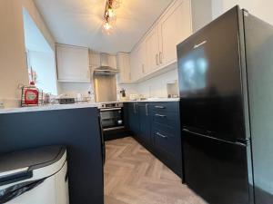 a large kitchen with a black refrigerator in it at Last minute discounts City Centre Business in Plymouth