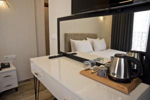 Habitación con cama y espejo en la encimera. en SULTAN SÜLEYMAN APART HOTEL, en Estambul