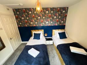 two beds in a room with a mural on the wall at Last minute discounts City Centre Business in Plymouth
