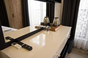 un mostrador blanco con dos mandos a distancia y un espejo en SULTAN SÜLEYMAN APART HOTEL, en Estambul