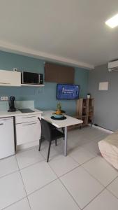 a kitchen with a table and a microwave at case à sucre in Les Trois-Îlets