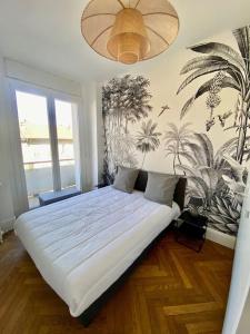a bedroom with a bed with a mural of plants at Superbe appartement hyper centre 4 personnes in Valence