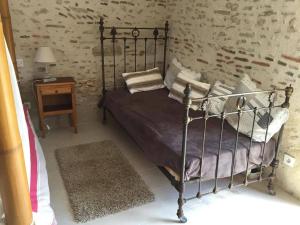 a bedroom with a metal bed and a night stand at CHAMBRE ROMANTIQUE in Mur-de-Sologne