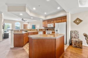 a kitchen with wooden cabinets and a white refrigerator at Branson Condo at Thousand Hills Walkin with Elevator Golf Front and close to 76 in Branson