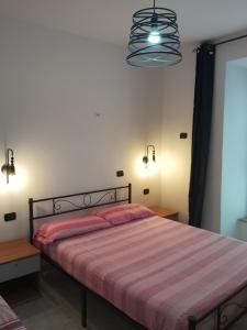 - une chambre avec un lit et une couverture rayée dans l'établissement Giallo Sole, à Colleferro