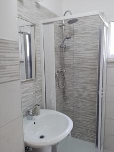uma casa de banho com um lavatório branco e um chuveiro em Giallo Sole em Colleferro