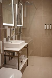 een badkamer met een witte wastafel en een douche bij By Friso Den Haag in Scheveningen