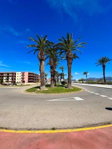 a street with palm trees on the side of a road at Vamos a PERTE DE VUE Linge de maison fournie in Empuriabrava