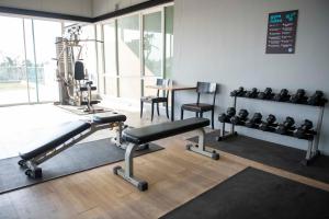 a room with a gym with a bench and weights at Mad Monkey Phuket in Patong Beach