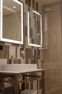 a bathroom with a sink and a mirror and a shower at By Friso Den Haag in Scheveningen