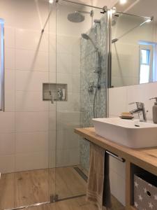 a bathroom with a sink and a shower at Haus Hyggelig direkt am Großen Zechliner See in Rheinsberg