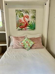 a bed with two pillows and a picture of a flamingo at Downtown Nassau Oasis Unit 3 in Nassau