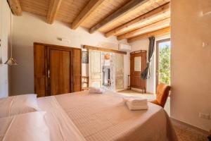 1 dormitorio con 1 cama grande y toallas. en Casale Millinchè, en Scicli