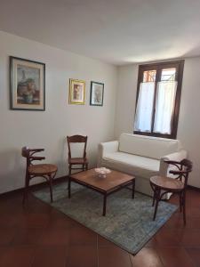 ein Wohnzimmer mit einem Sofa, 2 Stühlen und einem Tisch in der Unterkunft La taverna di Anna in San Pietro di Feletto