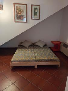 ein Bett auf einem Fliesenboden in einem Zimmer in der Unterkunft La taverna di Anna in San Pietro di Feletto