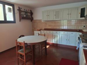 eine Küche mit einem Tisch und Stühlen in der Unterkunft La taverna di Anna in San Pietro di Feletto