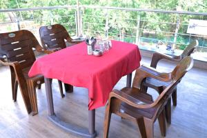 una mesa con un mantel rojo en el balcón en Kings Resort, en Silvassa