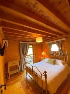 a bedroom with a bed in a room with wooden walls at ktima Tzouros - Κτήμα Τζούρος in Thermo