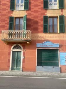 a red building with a door and a balcony at La casa di Raffa in Bonassola