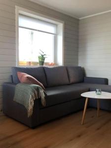een woonkamer met een blauwe bank en een tafel bij Koselig leilighet i Tromsø in Tromsø