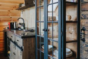 a kitchen with a glass cabinet with plates and wine glasses at Labieši in Jūrmala +37 photos