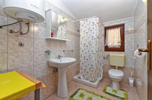 a bathroom with a sink and a toilet and a shower at Apartments Medulin 2315 in Medulin +46 photos
