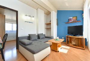 a living room with a couch and a tv at Apartments Medulin 2315 in Medulin