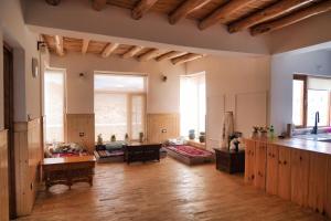 a large living room with wooden floors and windows at The Hermit Homestay in Leh