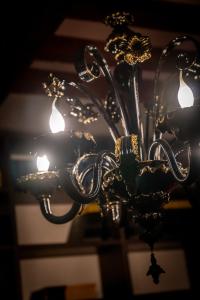 un primo piano di un lampadario a braccio con luci di Palazzo San Luca a Venezia