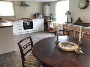 une cuisine avec une table en bois et des chaises ainsi qu'une salle à manger dans l'établissement A gorgeous, two double bedroom, period cottage., à Brasted