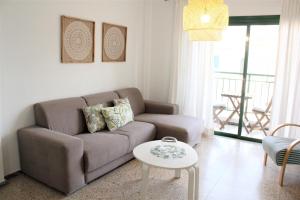 ein Wohnzimmer mit einem Sofa und einem Tisch in der Unterkunft Playa San Juan 3 bd apartment by the sea in Playa de San Juan