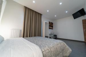 1 dormitorio con 1 cama blanca grande y TV en Alta Dimora, en Bitritto
