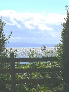una recinzione con vista sull'oceano dietro di essa di Moville Beach Townhouse on Wild Atlantic Way a Moville