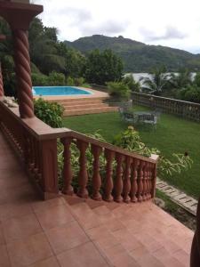 een balkon van een huis met een tuin met een zwembad bij Bayview Villa -Sea Side Villa in Mahe