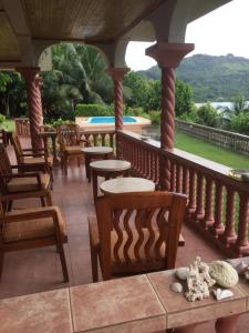 a porch with chairs and tables and a pool at Bayview Villa -Sea Side Villa in Mahe