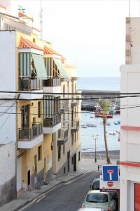 a building on a street next to the ocean at Playa San Juan 3 bd apartment by the sea in Playa de San Juan