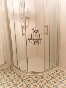y baño con ducha eléctrica nueva. en Moville Beach Townhouse on Wild Atlantic Way en Moville