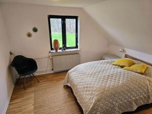 Un dormitorio con una cama con almohadas amarillas y una ventana en Privat lejlighed på landejendommen Frederiks-Eg, en Herlufmagle