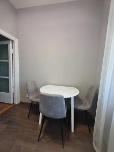 une table blanche et deux chaises dans une pièce dans l'établissement Irina apartament Stefan 64, à Chişinău