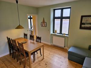 a living room with a table and chairs and a couch at Privat lejlighed på landejendommen Frederiks-Eg in Herlufmagle