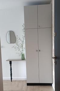 une armoire blanche dans une pièce avec une table dans l'établissement NOWY Apartament Bitwy Warszawskiej, à Siedlce