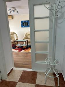 Una puerta de cristal que da a una habitación con sala de estar. en Harmony Luisa Apartment #Enjoy#Otopeni#, en Otopeni
