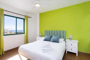 a green bedroom with a bed and a window at Nice 2 bd apartment by the sea in Playa San Juan in Playa de San Juan