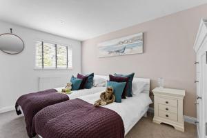 BeesandsにあるBumble Cottage, Torcrossのベッドルームにテディベアが座ったベッド2台が備わります。