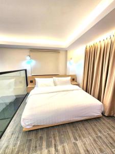 um quarto com uma grande cama branca e cortinas em Kenton House em Savannakhet