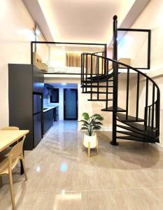 a living room with a spiral staircase and a potted plant at Kenton House in Savannakhet