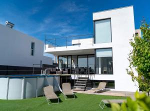 Casa blanca con patio con sillas en Moderna Villa con piscina en Palma de Mallorca en Palma de Mallorca