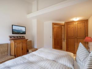 1 dormitorio con 1 cama y 1 silla en Appartement Hintermitterast en Kirchberg in Tirol